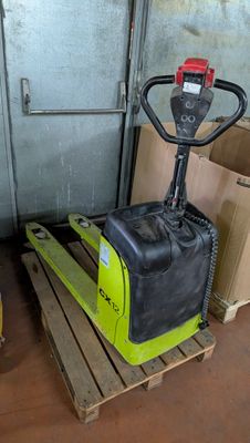 un chariot élévateur jaune posé sur une palette dans un entrepôt