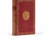 un vieux livre rouge avec un emblème doré sur la couverture