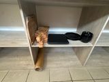 une étagère en bois sur laquelle sont posées une paire de chaussures et un sac