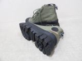 someone is wearing a pair of army green boots on a white surface