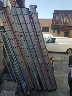 a truck that is parked next to a pile of ladders