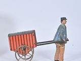 figurines of a man pulling a wagon with a horse and buggy