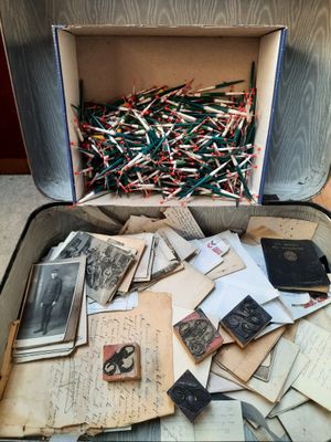 une valise ouverte remplie d'une multitude de vieilles photos et de papiers