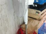 a fan that is sitting on the floor next to a stack of crates
