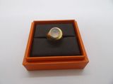 an orange box with a ring inside of it on a white surface