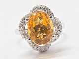 Bague en saphir jaune et diamants sur fond blanc