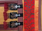 three pieces of red and orange silk with black and gold trims
