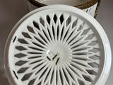 a white basket with a clock inside of it on a table