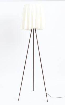 the floor lamp is made of metal and has a white shade on it