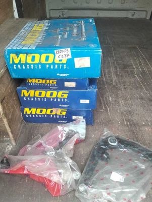 Des cartons contenant des pièces de moteur sont posés par terre à l'arrière d'un camion