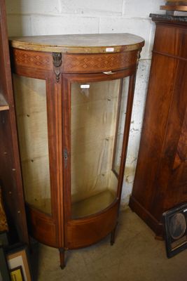 a corner cabinet with a marble top and a glass door