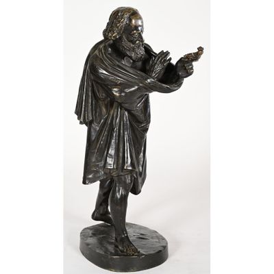 a bronze statue of a man holding a bird in his hand
