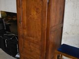une armoire en bois et une chaise dans un coin de la pièce
