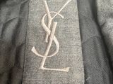 a close up of a black jacket with a white ysl logo on it