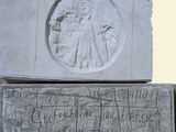 une plaque en pierre sur laquelle figure l'image d'un homme et d'un chien