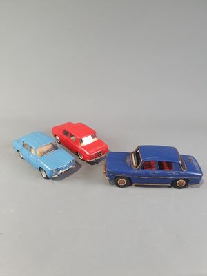 three toy cars are sitting side by side on a white surface