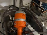 an orange electric drill in a sink with a wrenet