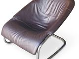fauteuil de salon en cuir marron avec structure métallique et repose-pieds, sur fond blanc