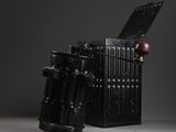 an old black metal box with a wooden handle and a wooden ball in it