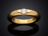 a yellow gold ring with a single diamond in the center
