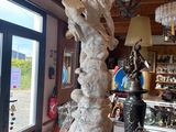 a statue of a woman holding a surfboard in a shop