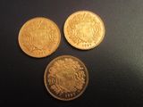 trois pièces d'or empilées les unes sur les autres sur une table