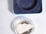 a small blue box with a silver coin inside of it