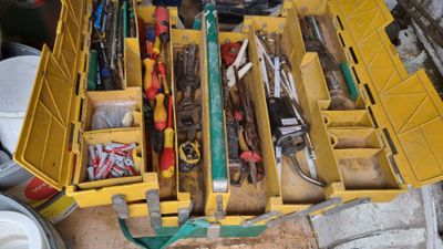 a yellow tool box filled with tools on the floor