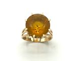 a close up of a ring with a yellow stone in it