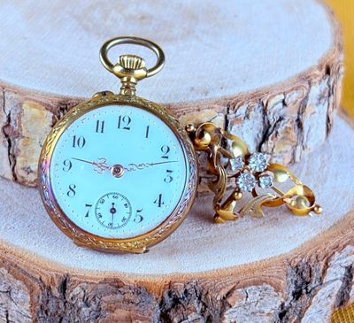 a pocket watch sitting on top of a piece of wood