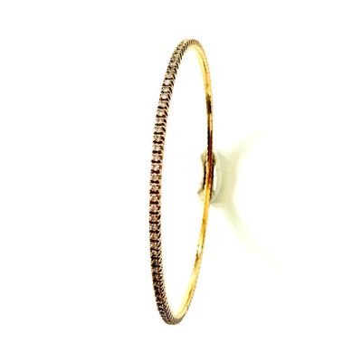 gros plan d'un bracelet en or avec des diamants sur fond blanc