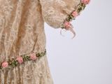 a dress that has pink flowers on it and is on a mannequin stand