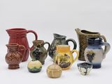 many different types of vases and pitchers on the table