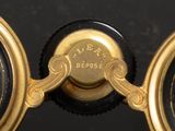 a close up of a gold clock with a black face