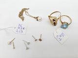 several different rings and earrings are displayed on a white surface