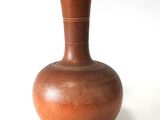 a brown vase sitting on a white surface