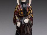 an old figurine of a woman in a traditional dress