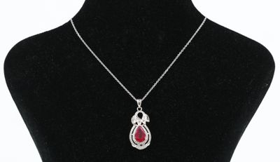 un collier en argent avec un pendentif rouge en forme de larme sur un mannequin noir