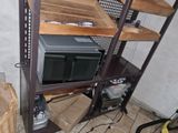 a microwave sitting on top of a shelf in the corner of a room