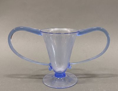 a blue glass cup with a handle on a table