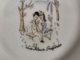 a plate with a picture of a man and a woman sitting on a bench