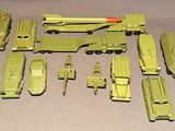Des véhicules militaires miniatures sont alignés les uns à côté des autres sur une table
