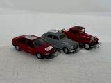 two toy cars sitting next to each other on a white surface