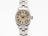une image représentant une montre argentée avec un cadran beige sur fond blanc