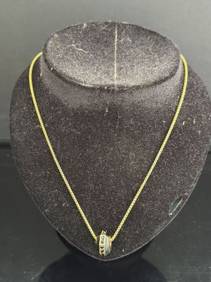 un collier en or avec un pendentif en diamant autour du cou d'un mannequin