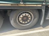 a green truck with a flat tire parked in a parking lot