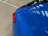 a blue car that is parked in a parking lot