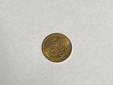 a gold coin sitting on top of a white surface