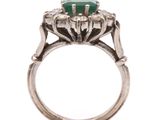a close up of a ring with a green stone on it