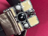 leather belt with a metal buckle on a pink background